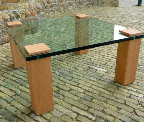 Salontafel met eiken poten en een dik glazen blad